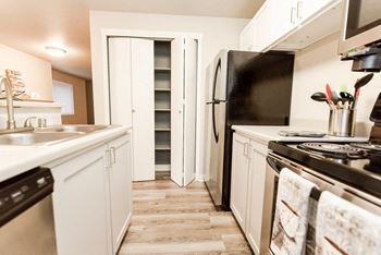 a kitchen with white cabinets and a stove and a refrigerator